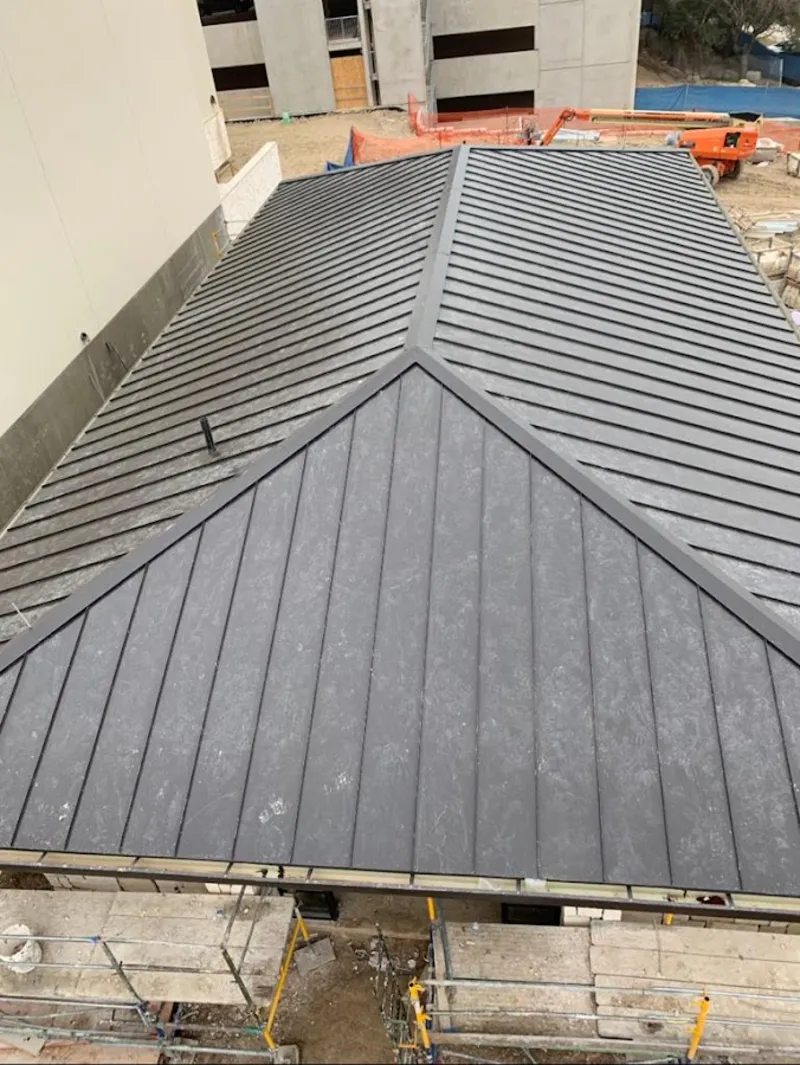 Commercial metal roof construction with crane equipment in Adelanto